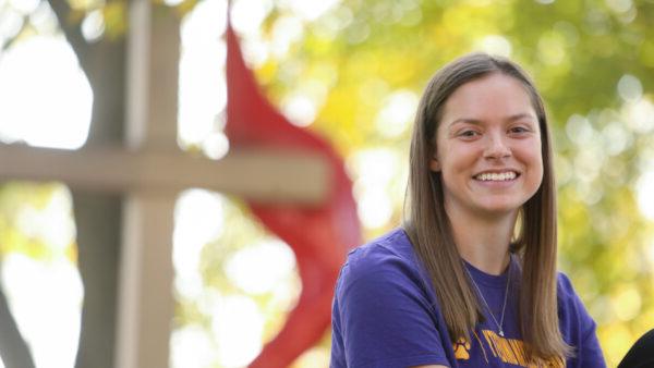 Female student sitting in front of cross